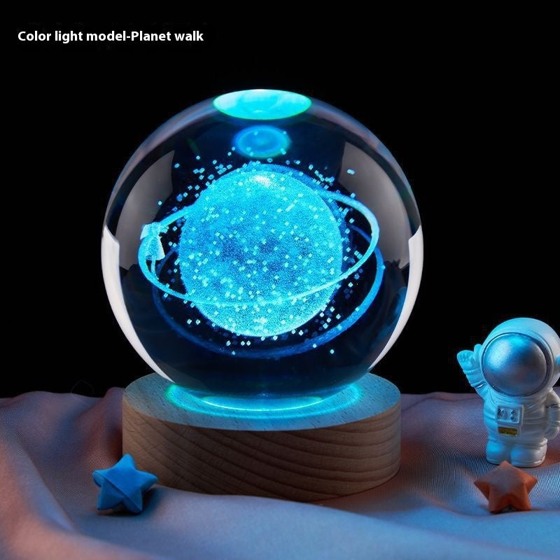 Glowing crystal ball with celestial design on a wooden base, surrounded by small stars and an astronaut figure.