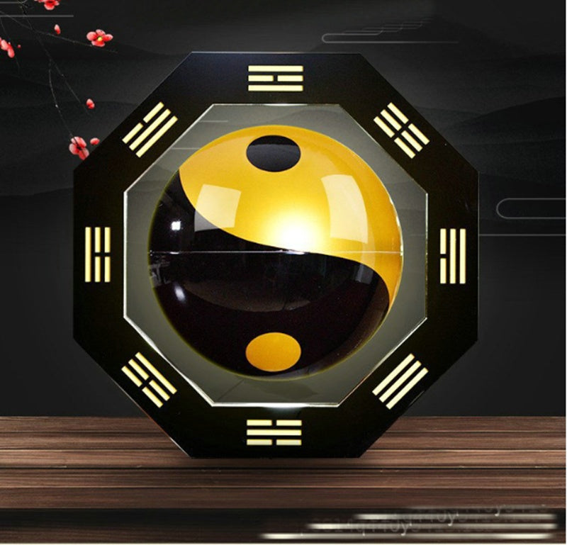Decorative wall light with a yin-yang symbol on an octagonal frame, placed on a wooden surface.