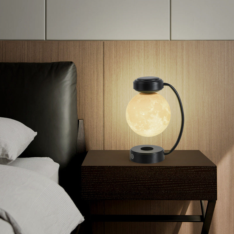 Modern table lamp on a bedside table with a bed and headboard in the background