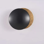 Round black object with a gold rim on a light gray background