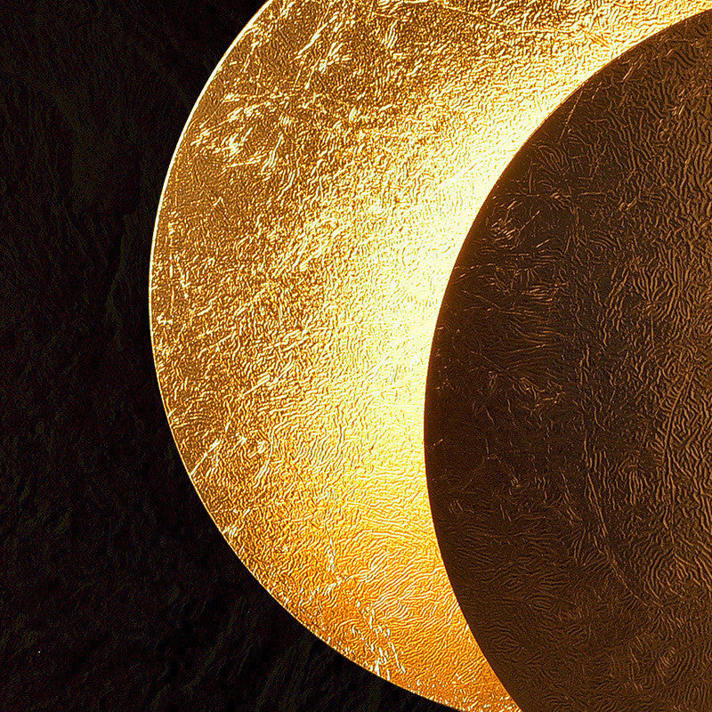 Close-up of a textured gold and bronze disc on a black background