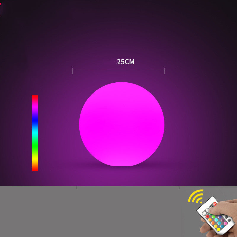 Purple glowing sphere with a 25cm measurement on a dark purple background, accompanied by a remote control.