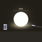 Round illuminated object with a remote control on a dark background