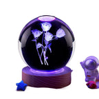 Crystal ball with floral design on a black background, surrounded by small decorative items.