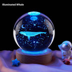 Glass ball with whale design on a wooden base, illuminated by blue light, with an astronaut figure in the background.