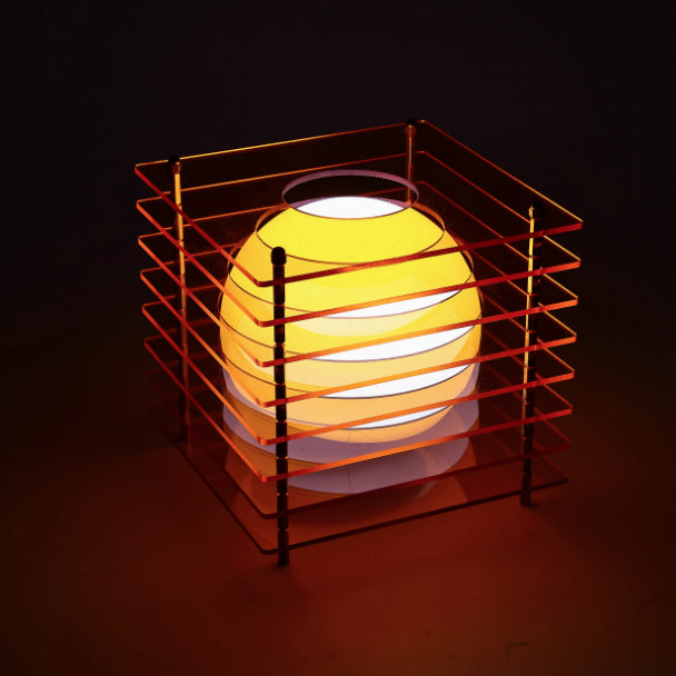 Yellow spherical lamp inside a red metal cage on a dark background