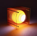 Yellow lamp with a wire cage on a dark background