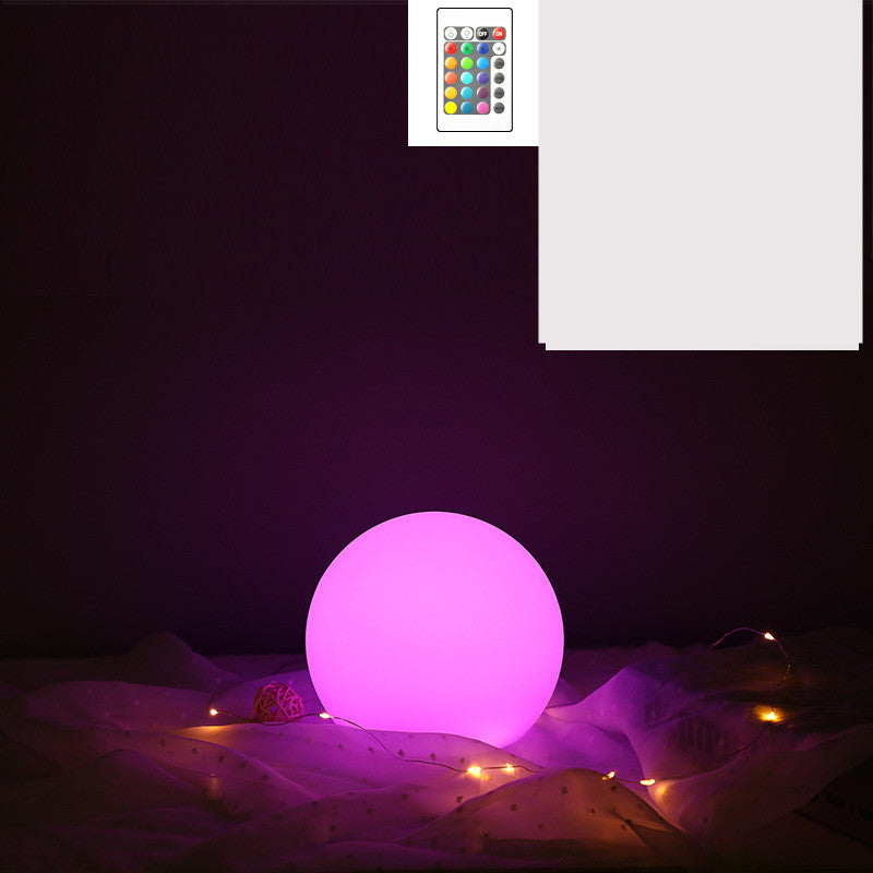 Purple LED light ball on a dark surface with a remote control inset showing color options.