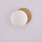 Wall light fixture with a wooden base and white shade on a light gray background