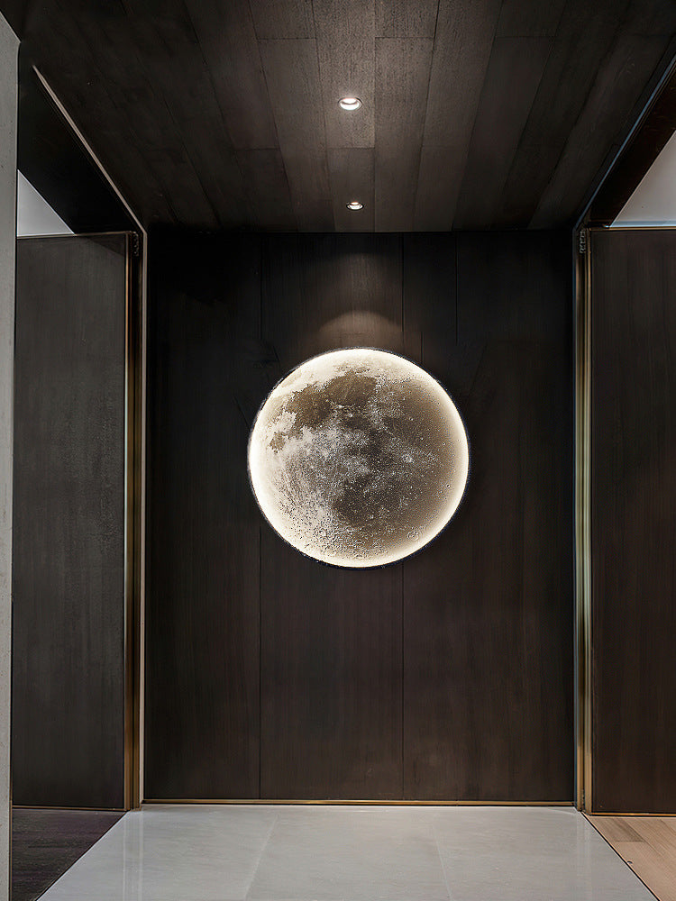 Modern interior with a large moon-like light fixture on a dark wall.