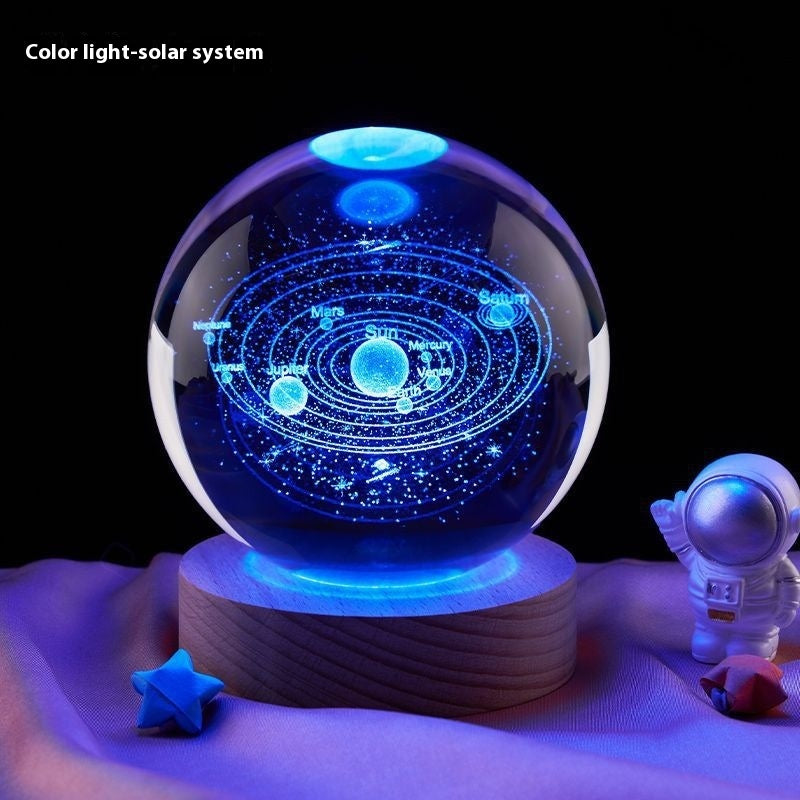 Solar system model in a crystal ball with an astronaut figure and stars on a dark background