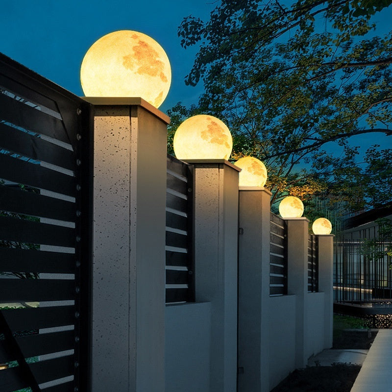 Decorative spherical lights on a fence at night
